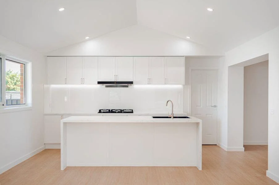 Finished white kitchen with island and warm timber floor